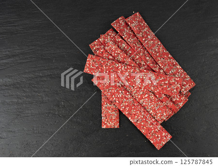 Beetroot crackers, thin rusk beet root bread, red diet multigrain crispbread, various seeds 125787845