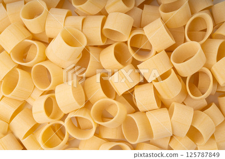 Raw Calamarata Big Pasta Isolated, Homemade Dry Macaroni, Italian Raw Round Noodle Raw Calamarata Big Pasta Isolated, Homemade Dry Macaroni, Italian Raw Round Noodle 125787849