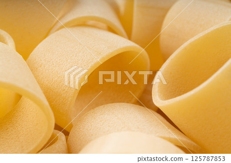 Raw Calamarata Big Pasta Isolated, Homemade Dry Macaroni, Italian Raw Round Noodle Raw Calamarata Big Pasta Isolated, Homemade Dry Macaroni, Italian Raw Round Noodle 125787853