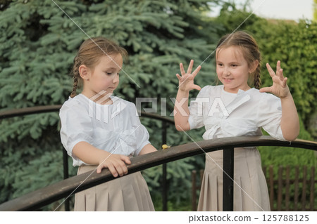 The twins intently observe the snail crawling along the railing. Their light clothing makes their figures appear even more delicate. 125788125