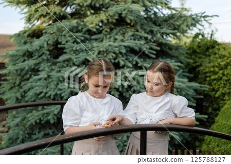 Twins in light clothing form the image of a fairytale duo. The look is enhanced by symmetrical hairstyles and gentle glances. 125788127