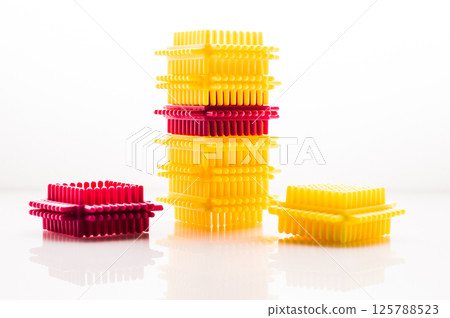 The children's building set consists of bright blocks that are easy to connect. The colorful elements on the white background create a positive mood. The children's building set consists of bright blocks that are easy to connect. The colorful elements on the white background create a positive mood. 125788523