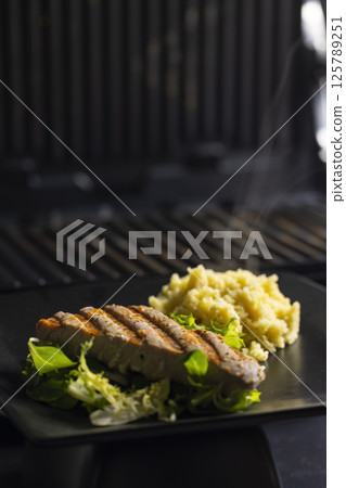 tuna fish steak with couscous and salad 125789251