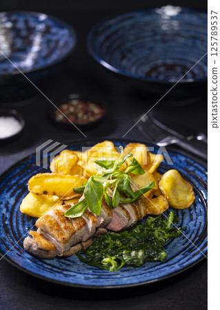 roasted duck breast with spinach and potato chips 125789537