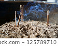 Incense sticks stuck in a censer 125789710