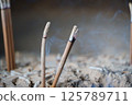Incense sticks stuck in a censer 125789711