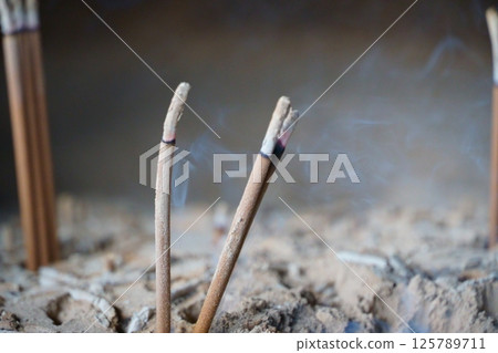 Incense sticks stuck in a censer 125789711