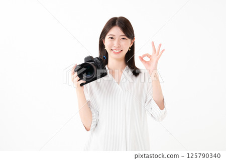 Smiling woman holding a camera 125790340
