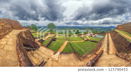 Panorama of ancient ruins on Sigiriya Rock with green landscape and stormy clouds Panorama of ancient ruins on Sigiriya Rock with green landscape and stormy clouds 125790455