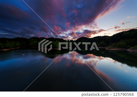Dynamically changing scenery in the evening sky after the rain. After the climax, the sunset sky gradually disappears. Lake ⑤ Dynamically changing scenery in the evening sky after the rain. After the climax, the sunset sky gradually disappears. Lake ⑤ 125790568