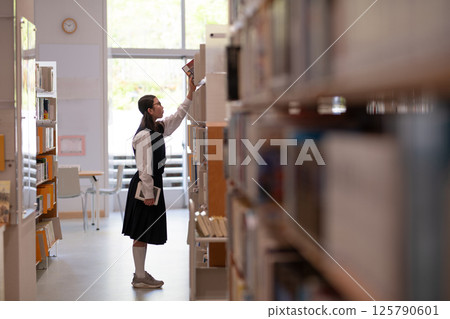 Junior high school girl choosing a book 125790601
