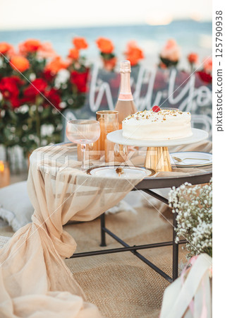 Beach Proposal Decor with Will You Marry Me Sign, Flowers and Cozy Area. Will You Marry Me Proposal Beach Proposal Decor with Will You Marry Me Sign, Flowers and Cozy Area. Will You Marry Me Proposal 125790938