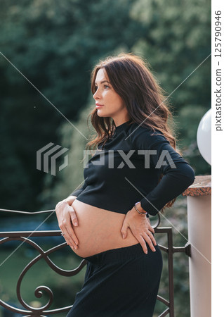 Beautiful pregnant woman at home in the doorway Beautiful pregnant woman at home in the doorway 125790946