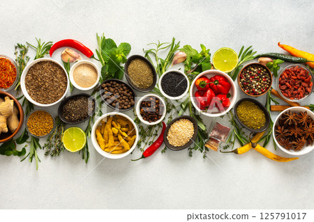 A collection of various spices and herbs on a gray background, perfect for enhancing dishes with rich flavors and textures A collection of various spices and herbs on a gray background, perfect for enhancing dishes with rich flavors and textures 125791017