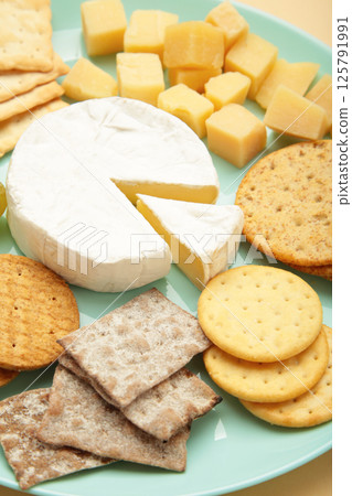 Different types of cheese with crackers on mint plate. Vertical photo 125791991