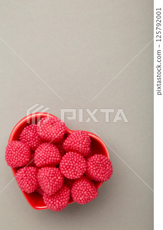 Raspberry and blackberry candy on bowl on grey background. Top view 125792001