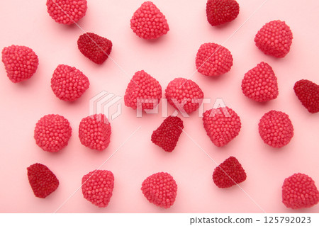 Red chewing sweets in the form of berries. Sweets in the form of raspberries on pink background. Space for text 125792023