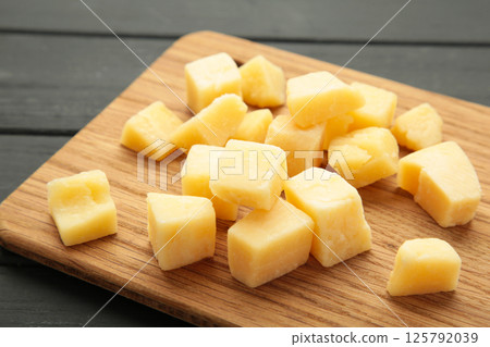 Cheese cubes on cutting board on black background. Parmesan Cheese cubes on cutting board on black background. Parmesan 125792039