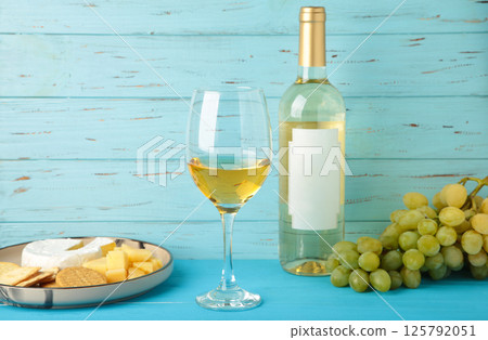 Wine tasting. Parmesan cheese with glass of wine and grape on blue background. Cheese plate. Wine card, restaurant menu. 125792051