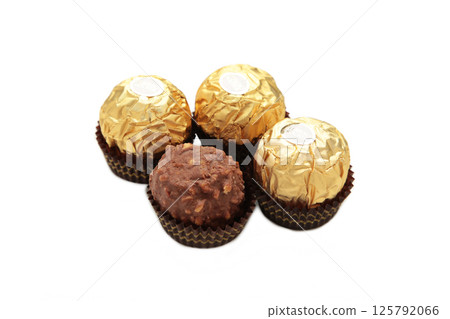 Mykolaiv, UKRAINE - July, 2024 Ferrero Rocher - round chocolates isolated on white background. Candy in branded packaging, a sweet pleasure for children and adults 125792066