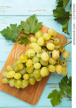 Shine muscat grape with leaves on blue background. Top view 125792082