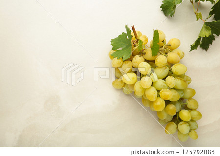 Green grape with leaves on light background. Top view Green grape with leaves on light background. Top view 125792083
