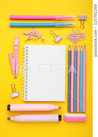 Studio shot of school supplies on yellow background. Vertical photo 125792169