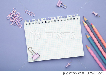 School supplies concept. Open notebook with colorful pencil on purple background School supplies concept. Open notebook with colorful pencil on purple background 125792223
