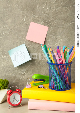 School accessories concept. Photo of stationery on grey background. Vertical photo 125792229