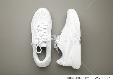 White sneakers on a grey background. Space for text 125792247