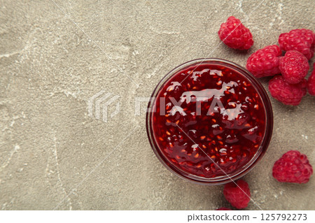 Raspberry jam jelly in bowl with berries on grey concrete background. 125792273