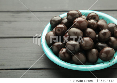 Blue bowl of pickled black olives, top view 125792358