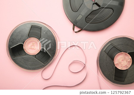Film reel on pink background. Space for text. Vertical photo Film reel on pink background. Space for text. Vertical photo 125792367
