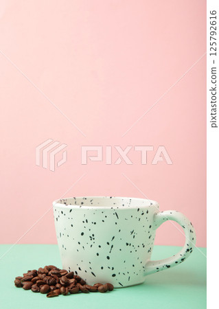 Coffee beans in white cups on pink background. Top view 125792616