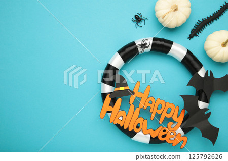 Halloween wreath with mini pumpkins on blue background. Thanksgiving decor. Top view 125792626
