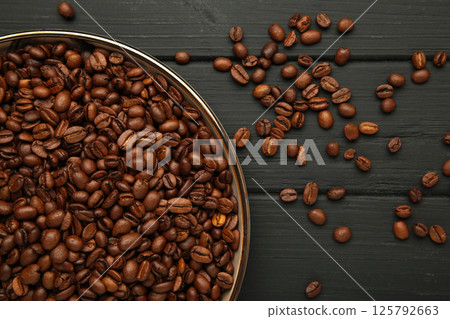 Coffee beans on plate on black background 125792663