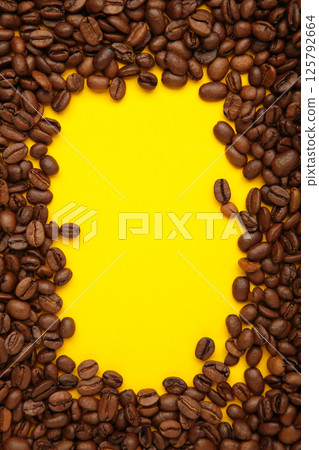 Black coffee beans on yellow background. Space for text 125792664