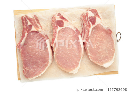 Sliced raw pork meat on cutting board isolated on white background. 125792698