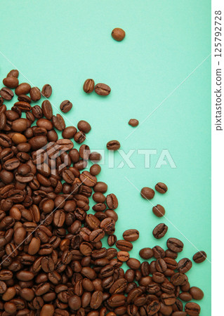 Roasted coffee beans on mint background. Space for text Roasted coffee beans on mint background. Space for text 125792728