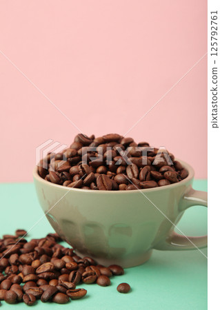 Coffee beans in coffee cup on colorful background. Vertical photo 125792761