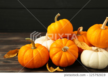 Festive autumn decor from pumpkins and leaves on black wooden background. Concept of Thanksgiving day or Halloween. 125792819