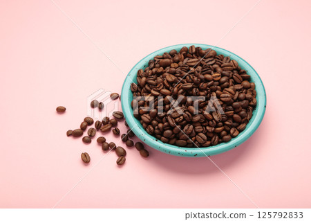 Coffee beans on plate on pink background Coffee beans on plate on pink background 125792833