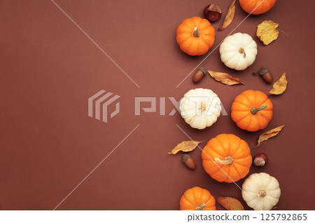 Autumn composition. White and orange pumpkin with autumn leaves on brown background. Thanksgiving day Autumn composition. White and orange pumpkin with autumn leaves on brown background. Thanksgiving day 125792865