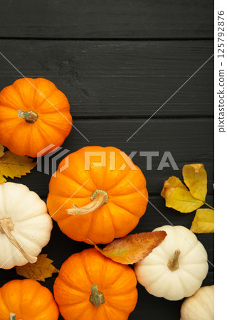 Autumn composition. White and orange pumpkin with autumn leaves on black background. Thanksgiving day 125792876