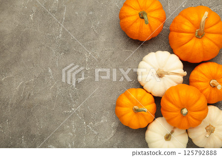 White and orange pumpkins on grey concrete background. Space for text White and orange pumpkins on grey concrete background. Space for text 125792888