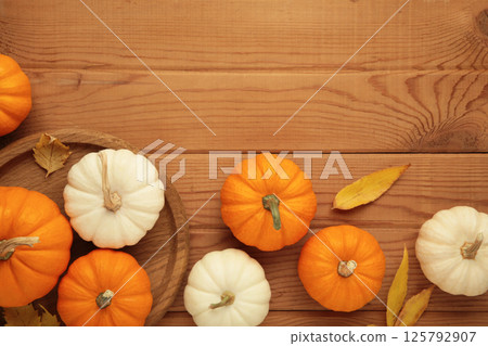Autumn composition. White and orange pumpkin with autumn leaves on wooden background. Thanksgiving day 125792907