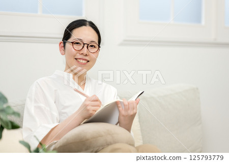 Well-bee woman reading on sofa | Study | Hobby | Healthy living image | Well-bee girl | Well-being Well-bee woman reading on sofa | Study | Hobby | Healthy living image | Well-bee girl | Well-being 125793779