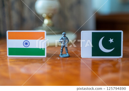 A tin soldier on the background of the flags of India and Pakistan. India Pakistan military conflict 125794890