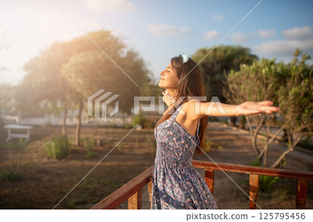 Happy smiling woman raising her hands up. 125795456