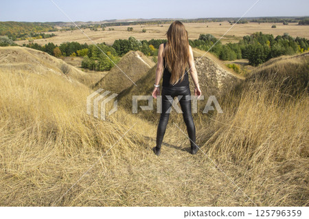 Beautiful strong dark haired woman in black clothes outdoor in the nature enjoy with freedom Beautiful strong dark haired woman in black clothes outdoor in the nature enjoy with freedom 125796359